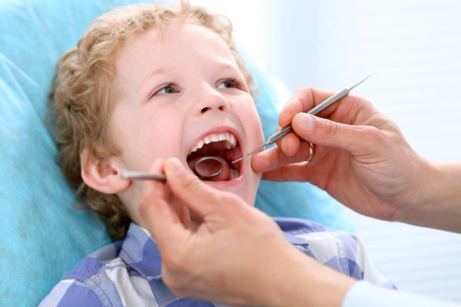 young boy getting a dental checkup during summer break